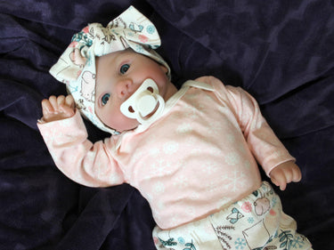 A baby doll resting on a bed beside, creating a cozy and playful scene.